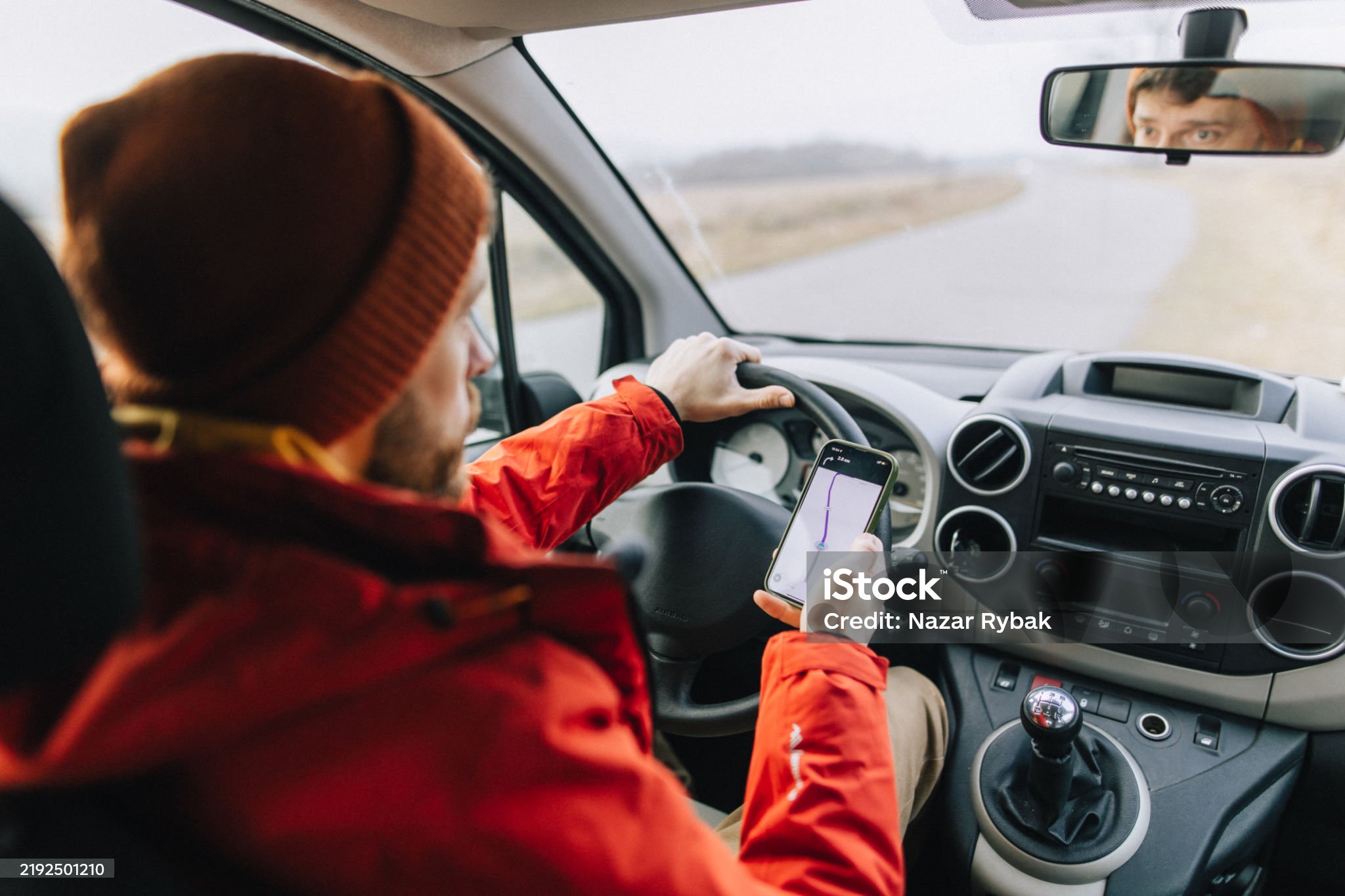 A man confidently uses a mobile app for navigation while driving, ensuring a smooth and efficient journey